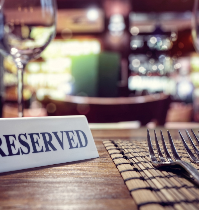 Restaurant reserved table sign with places setting and wine glasses ready for a party